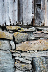 Fototapeta premium Foundation of stones with old wooden wall upon it. 