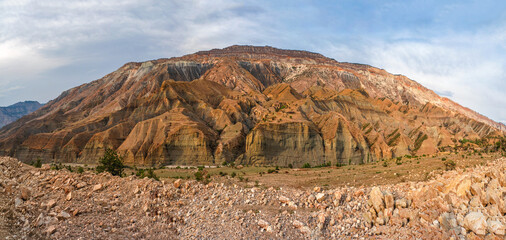 Panoramic view of the red mountain cut by canyons.