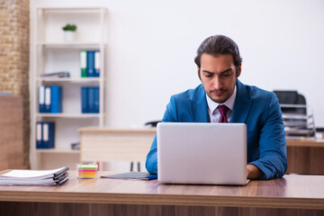 Young male employee working at workplace