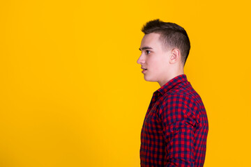 A handsome guy in a red shirt on a yellow background 