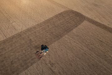 Acricultural tillage or land preparation before sowing. Tractor cultivating a field with harrow....