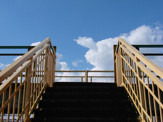 Harsh iron stairs against the background of the summer blue sky