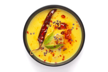 Close-up of Indian traditional kadhi or kadi pakora yogurt and gram flour and turmeric served hot in a black bowl. Over a white background.
