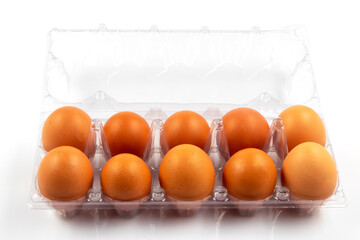 Overhead view of brown chicken eggs in an open egg box isolated on white background. Fresh chicken eggs. Natural healthy food and organic farming concept. Eggs in box.