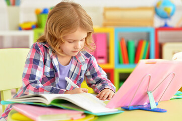 Cute teen girl doing homework in her room