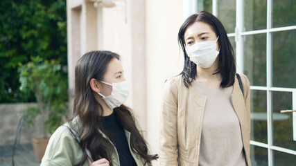 マスクをして歩く二人の女性　ショッピング