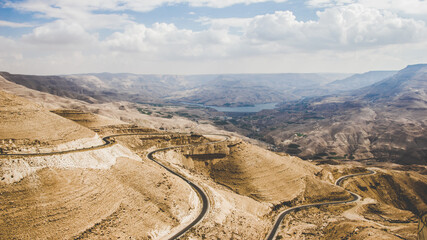 Fototapeta na wymiar A magnificent view of Wadi Mujib and the king's highway in Jordan with a blue cloudy beautiful sky