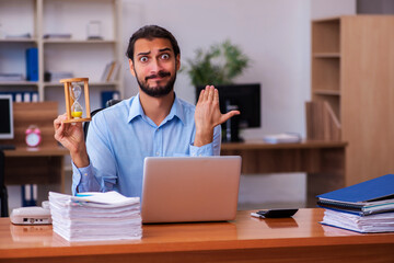 Young male employee in time management concept