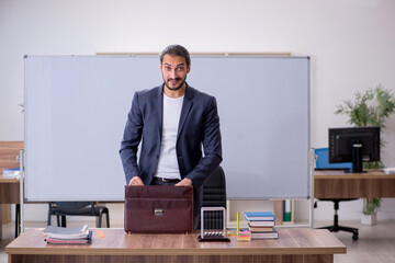 Young male teacher physicist in the classroom