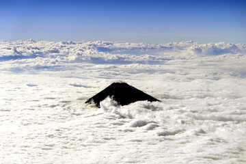 一面の荒々しい雲海から頭を出す富士山