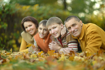 Fototapeta premium Family of four relaxing in autumn park