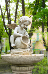 Fototapeta na wymiar Cupid marble garden sculpture and decorative fountain