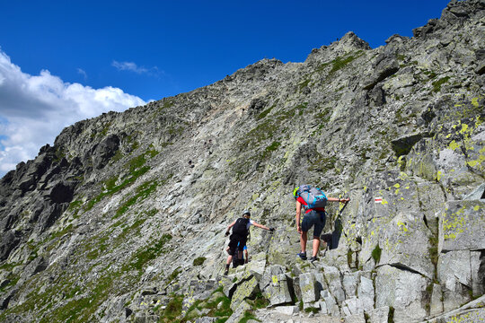 Hikers climbing to the peak of mount Rysy, one of the highest mountains of the High Tatras. Slovakia, Poland.