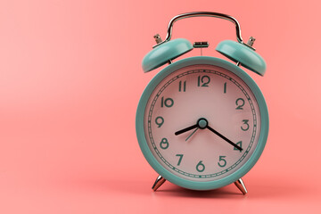 Old clock isolated on a pink background with space for text. Concept of time