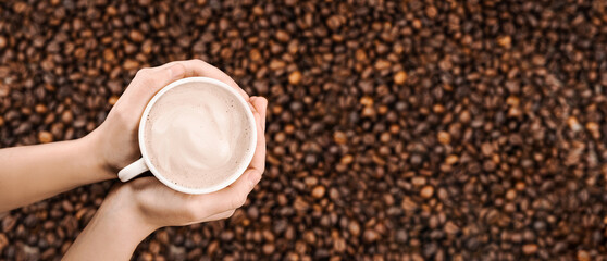 A cup of coffee in hands. Background of kogo bean - obrazy, fototapety, plakaty