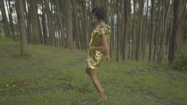 Mujer transgénero corriendo libremente por el interior del bosque 