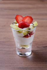 Fruit shot of yogurt and pieces of fruit and berries. Useful for health. On a wooden background, close-up