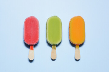 Fruit ice cream, popsicles on stick.  Red, green and orange frozen vegan sorbet. Water ice summer dessert