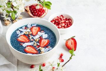 Butterfly pea flower chia pudding with strawberries, pomegranate and granola.