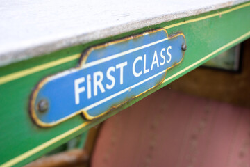 Close up of a first-class sign on a miniature railway carriage