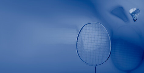 Badminton racket and shuttlecock on blue background. Professional sport concept