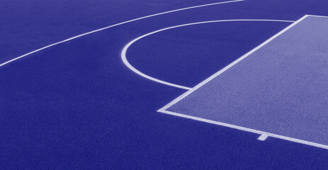 Abstract, blue background of newly made outdoor basketball court. Visible asphalt texture, freshly painted lines. Blue color filter