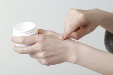 Woman applying cream on hand