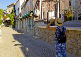 Young woman walking in narrow street in Alacati, Cesme Turkey	