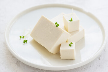 Tofu slices with micro greens on a plate.