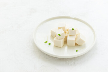 Pieces of tofu with micro greens on a plate.