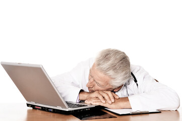 Elderly tired doctor with a laptop on white background