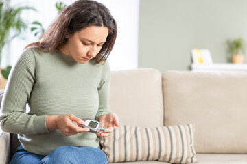 Young woman measures blood sugar level
