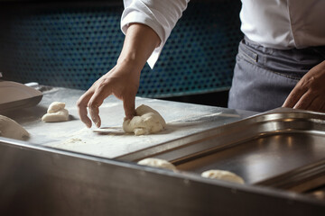 Making dough for bread by male hands in restaurant kitchen. Cooking concept.