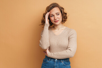 Young ginger woman with headache touching her forehead