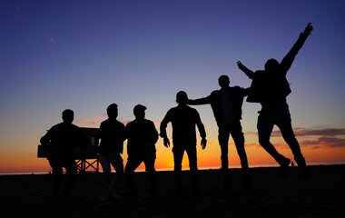 Fototapeta na wymiar people jumping on the background of the sunset