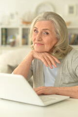 senior woman sitting at table with laptop