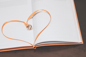 A beautiful heart in an open book in the form of a bookmark, a place for text