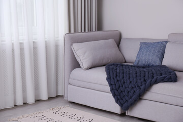 Living room interior with knitted merino wool blanket on sofa