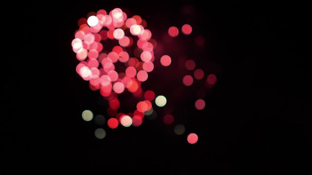 Shimmery like sequins bokeh pink fireworks balls at night sky holiday background Blurry firework