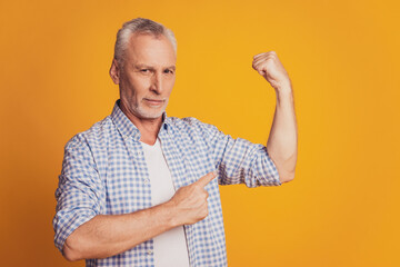 Portrait of proud gray-haired man showing biceps isolated over background