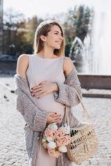 Beautiful pregnant girl walking the fountain.