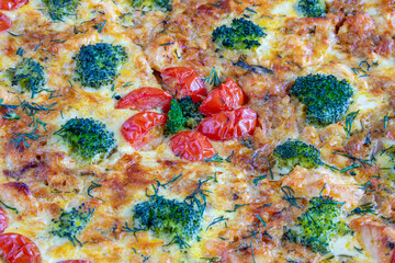 Homemade pie with salmon, tomatoes and broccoli close up