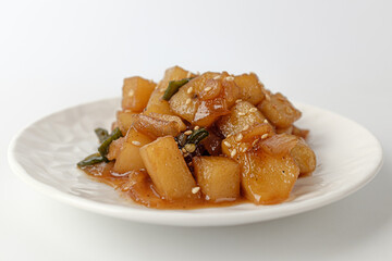 Simmered potatoes in soy sauce on a white background