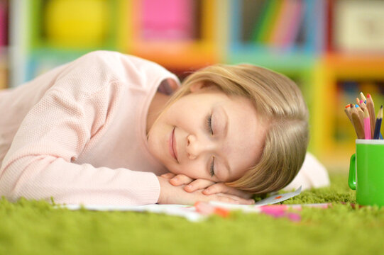 cute little girl sleeping on green carpet