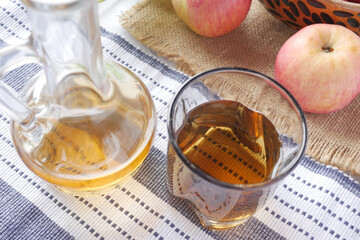 apple vinegar in glass bottle with fresh green apple on table 