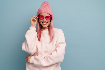 Young white woman with pink hair wearing sunglasses and smiling