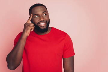 Handsome dark skin guy thinking looking aside copy-space isolated over pink background
