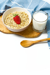 Healthy food. Oat flakes with fresh strawberry in white bowl, isolated on white background. copy space