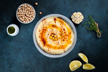 Traditional Middle east appetizer Hummus served with lemon and tahini, seasoned with extra virgin olive oil and paprika in ceramic plate. eastern dish. Vegetarian dish. Traditional dip with chickpea