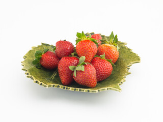 Świeże, dojrzałe , czerwone truskawki na talerzu w kształcie liścia